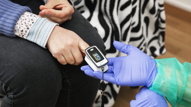 Eine Frau lässt sich den Blutdruck messen.