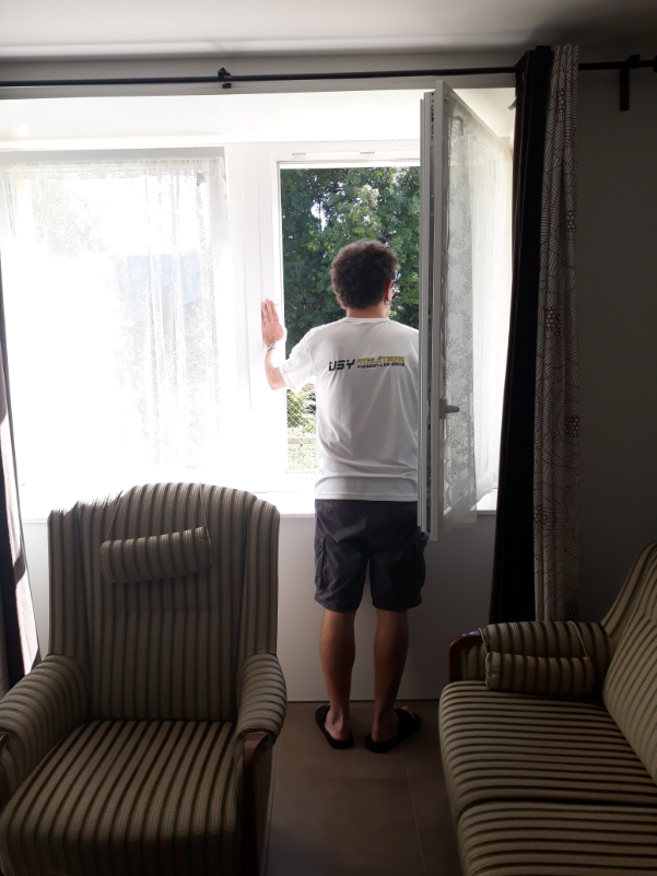 Ein Mann von hinten, der aus dem Fenster schaut.