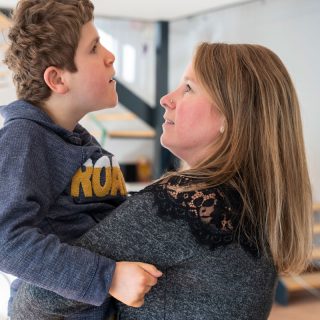 Une mère tient dans ses bras son fils en situation de handicap