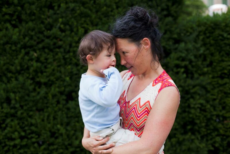 Eine Mutter trägt ihren Sohn mit Down-Syndrom