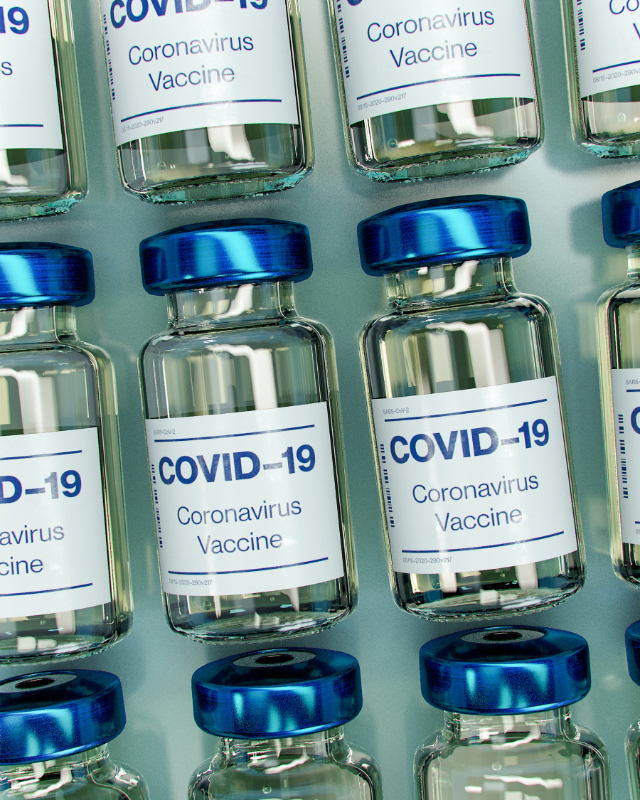 Mehrere Impfdosen gegen COVID-19 nebeneinander aufgereiht.