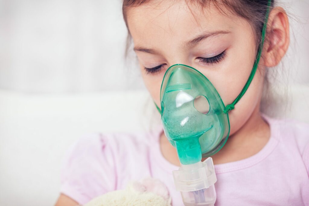 Une petite fille porte un inhalateur pour pouvoir respirer.